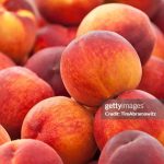 Heap of fresh organic peaches on display at a market.